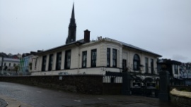 The White Star Line building where the last 123 passengers to board the Titanic got aboard. Cobh -- then called Queenstown -- was Titanic's last port of call. In the background is the spire of St. Colman's Cathedral, which was the last glimpse of Ireland for many emigrants as they sailed out of the port.
